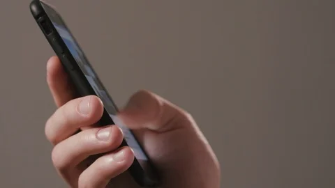 A Hand Using a Smartphone Against a Dark Background Stock Footage 88454189