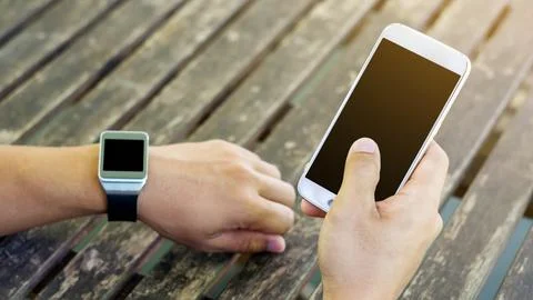Hand using a smartphone and a smartwatch. Stock Photos