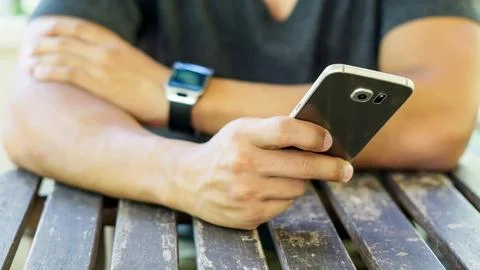 Hand using a smartphone and a smartwatch. Stock Photos