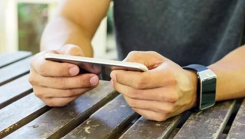 Hand using a smartphone and a smartwatch. Stock Photos
