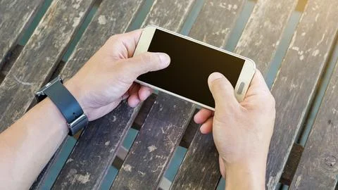 Hand using a smartphone and a smartwatch. Stock Photos