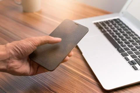 Hand using smartphone at the desk Stock Photos