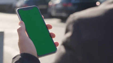 Hand using smartphone with greenscreen outdoor in city Stock Footage 125692829