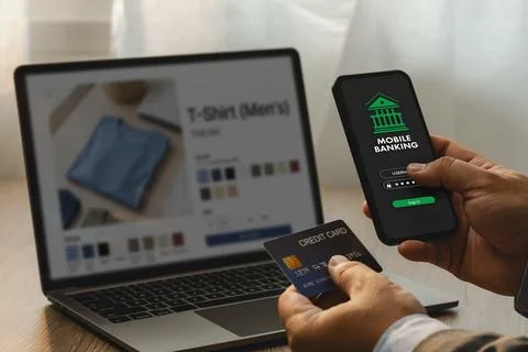 Hand using smartphone mobile banking login beside credit card and laptop sh.. Stock Photos