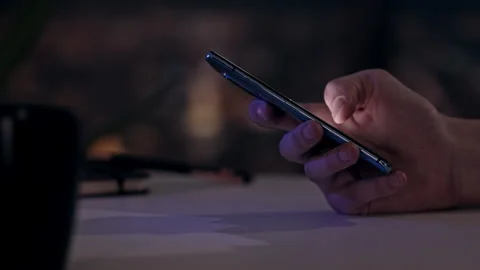Hand using smartphone in office at night Stock Footage 245483340