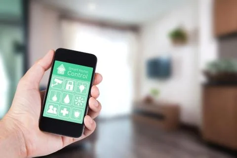 Hand using smartphone to smart home app on mobile for remote control everythi Stock Photos