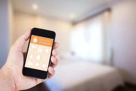 Hand using smartphone to smart home app on mobile for remote control everythi Stock Photos
