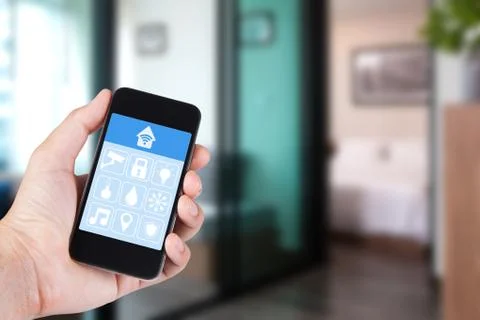 Hand using smartphone to smart home app on mobile for remote control everythi Stock Photos