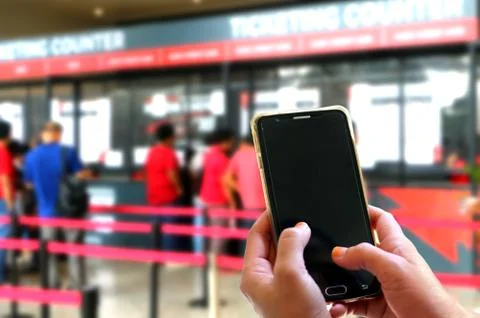 Hand using smartphone at ticketing counters Stock Photos