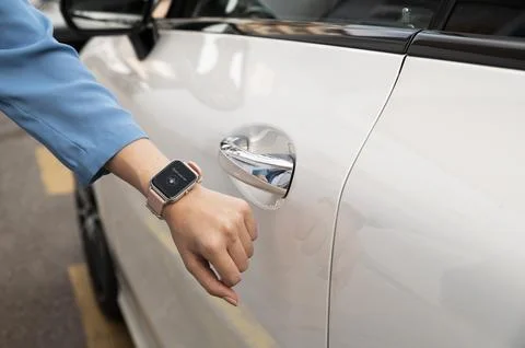 Hand using smartwatch to unlock car close up Stock Photos