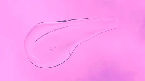 Hand using spatula applies smear of shampoo or shower gel on pink background. Stock Footage 280450632