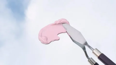 Hand using spatula makes a smear of cosmetic pink clay against the background of Stock Footage 280164088