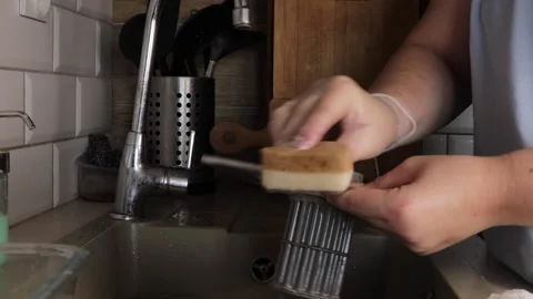 Hand using a sponge to clean removable plastic parts of a dishwasher, maint.. Stock Footage 320737947
