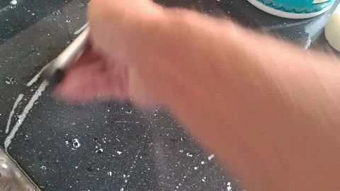 Hand using a squeegee cleaning dark wet kitchen counter video footage Video stock 339247358