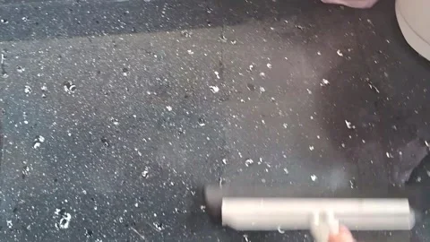 Hand using squeegee tool on dark kitchen countertop video footage Video stock 339247378