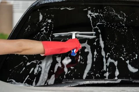 Hand using squeegee to washing windshield of car Foto stock