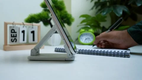 Hand using a stylus on a tablet with a calendar showing September 11 in the.. Stock Footage 316902076