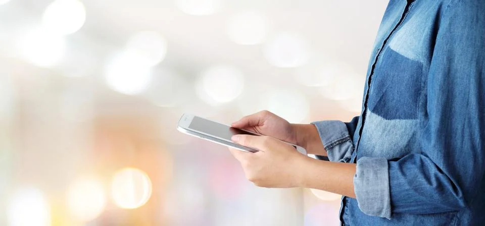 Hand using tablet over blur store with bokeh light background, banner, busine Stock Photos