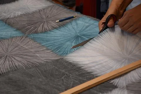 Hand Using Tailor Shears to Cut Patterned Fabric in Workshop Foto stock