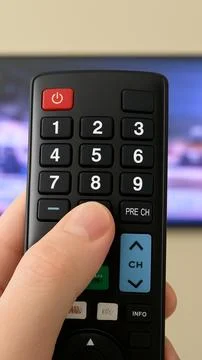 Hand using television remote control changing channel Foto stock