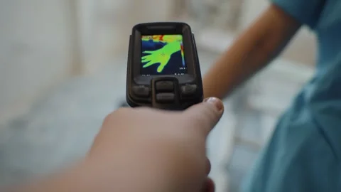 Hand using thermal imager to scan human body temperature Video stock 316843815