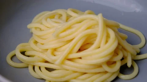 Hand using tongs to pick out the boiled spaghetti and put it on a plate. 動画素材 179295967