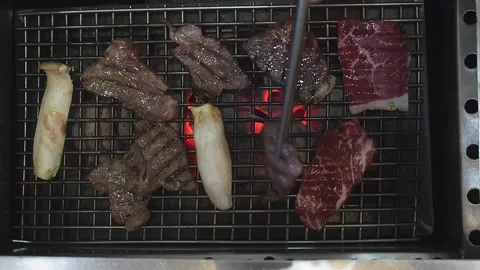Hand Using Tongs For Turning Meat on the Grill. Grilled meat on the grill. Stock Footage 149474166