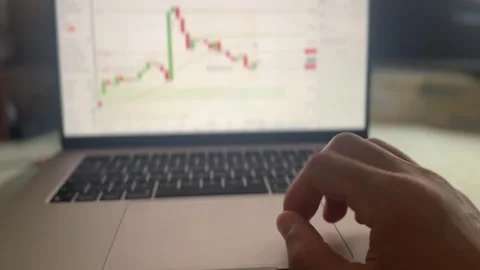 Hand using a trackpad on a laptop as it surveys a trading chart for a commodity Video stock 336183193
