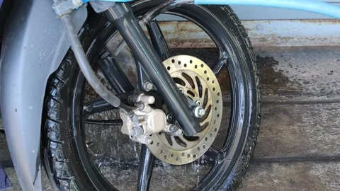 Hand is using water hose the motorcycle front wheel Stock Footage 155132577