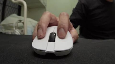 Hand Using White Computer Mouse on Black Desk Surface in Indoor Room Close Up Video stock 337739584