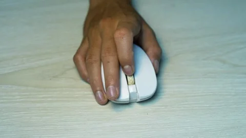 Hand using a white computer mouse on wooden desk, Close-up of a person usin.. Video stock 345119602