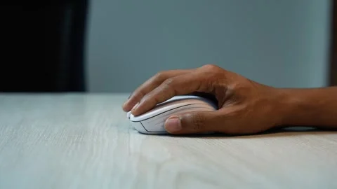 Hand Using Wireless Mouse on Wooden Desk, Close-up of a hand using a white .. Stock Footage 346483985
