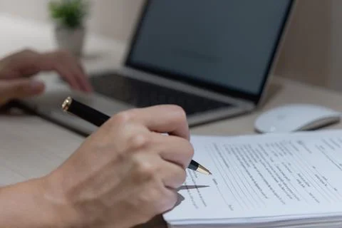 Hand using writing pen with paperwork in business company personal informat.. Stock Photos