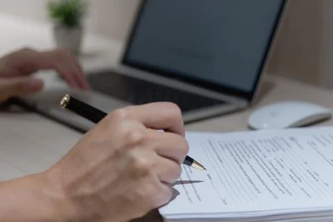 Hand using writing pen with paperwork in business company personal informat.. Stock Photos