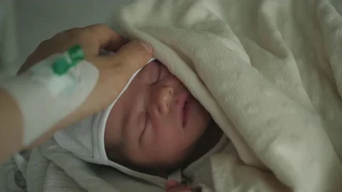 Hand with a venflon strokes stroking head of a newborn child hospital Video stock 130794834