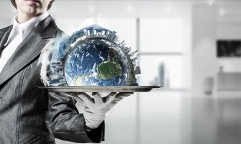 Hand of waitress presenting Earth globe on tray. Stock Photos