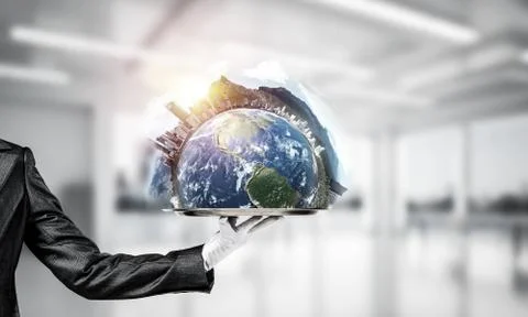 Hand of waitress presenting Earth globe on tray. Stock Photos