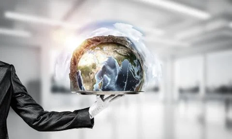 Hand of waitress presenting Earth globe on tray. Stock Photos