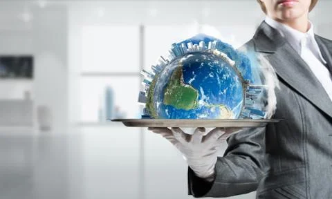 Hand of waitress presenting Earth globe on tray. Stock Photos