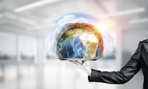 Hand of waitress presenting Earth globe on tray. Stock Photos