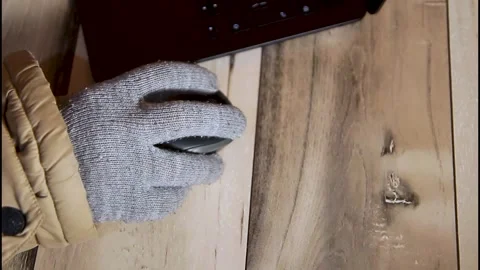 Hand in a warm glove using a computer mouse during winter blackout Stock Footage 328063038