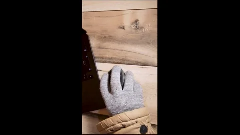 Hand in a warm glove using a computer mouse during winter blackout Stock Footage 328063041