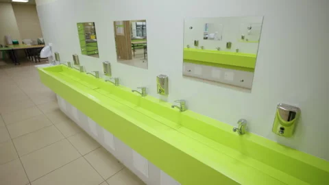 Hand wash basin with chrome taps and mirrors in canteen Stock Footage 335194061
