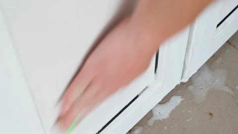 A hand washes a white plastic door with a sponge and foam detergent, close-up Stock Footage 201868865