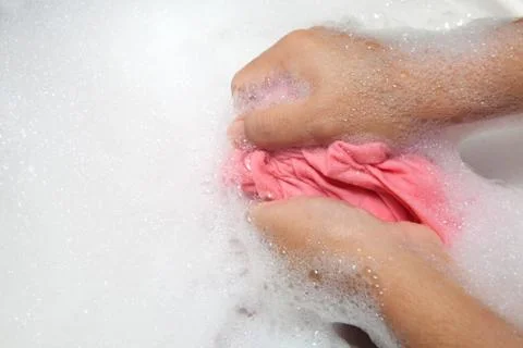 Hand washing clothes with bubble on white basin. Stock Photos