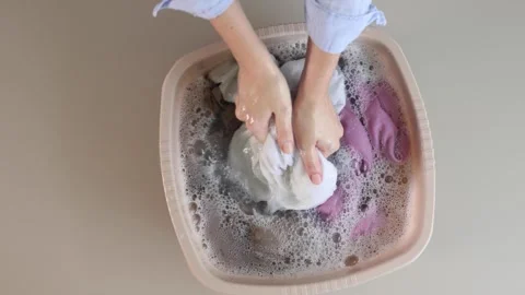 Hand washing clothes in soapy water at home Stock Footage 346403049