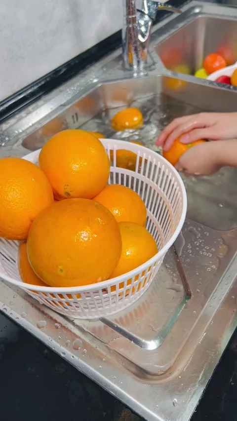 Hand Washing Fresh Organic Oranges in Modern Home Kitchen Sink Stock Footage 337740982