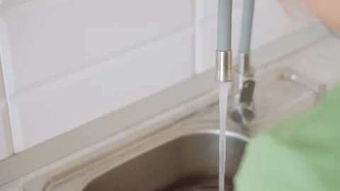 Hand Washing Whisk Under Flowing Water While Holding Knife Beside Sink Stock Footage 321088546