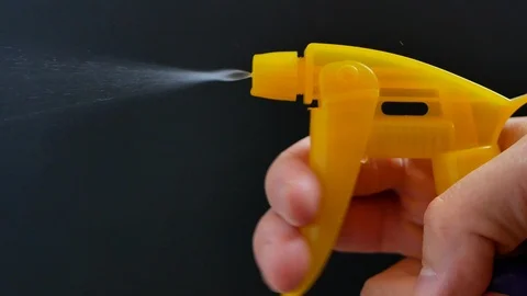 Hand with water sprayer sprinkle splashes of detergent on black background 库存影片 119195273