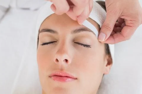 Hand waxing beautiful woman's eyebrow Stock Photos